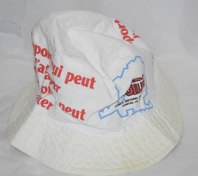 Cat.No: 174011 Cloth hat imprinted with the slogan; "N'Importe qui peut l'attraper, tout le monde peut l'eviter" roughly translates as [Anyone can catch it, everyone can avoid it]. Comite National de Lutte Contre le SIDA.
