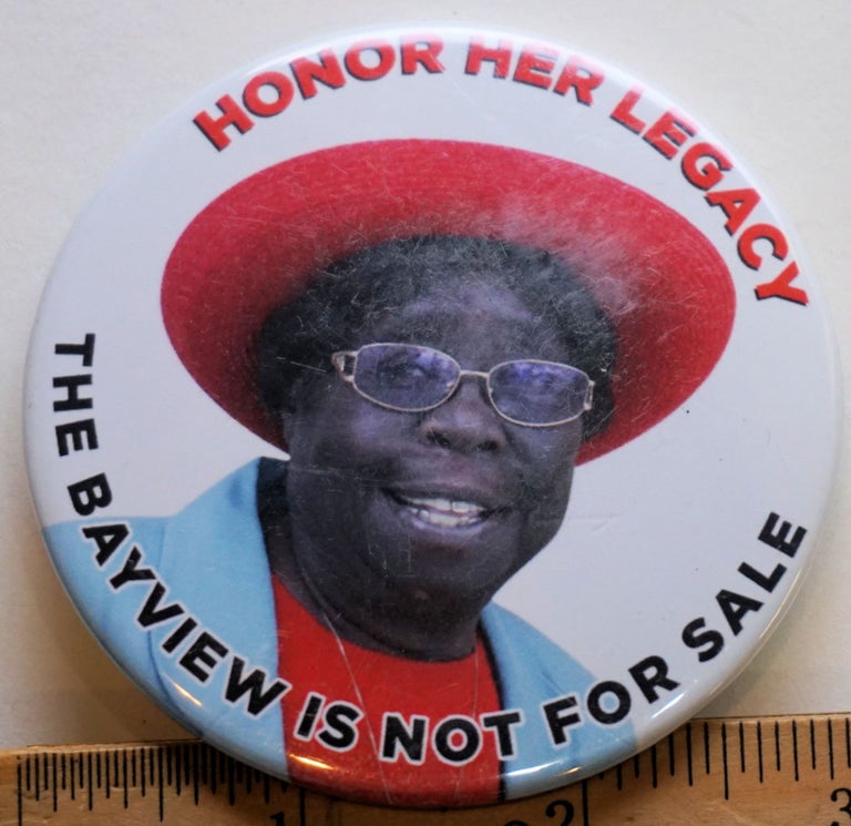 Cat.No: 226868 Honor Her Legacy; The Bayview is not for Sale [3-inch pinback button with text in red and black on a colorphoto field (activist in a red hat and skyblue coat)]