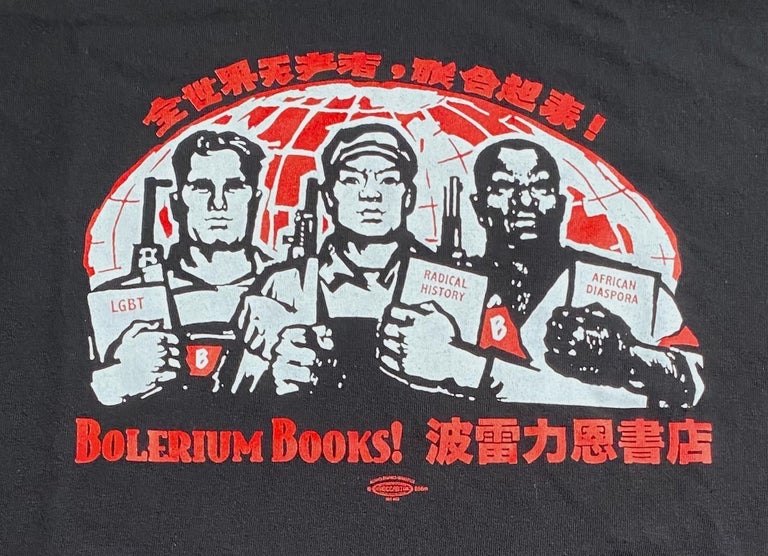 Cat.No: 269608 [X-LARGE t-shirt] Bolerium Books (design based on a Chinese poster celebrating internationalism. Chinese text above says "Proletarians of the world, unite!" Bolerium Books is repeated in English and Chinese)